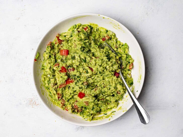 avocados mashed and mixed with other ingredients in large bowl