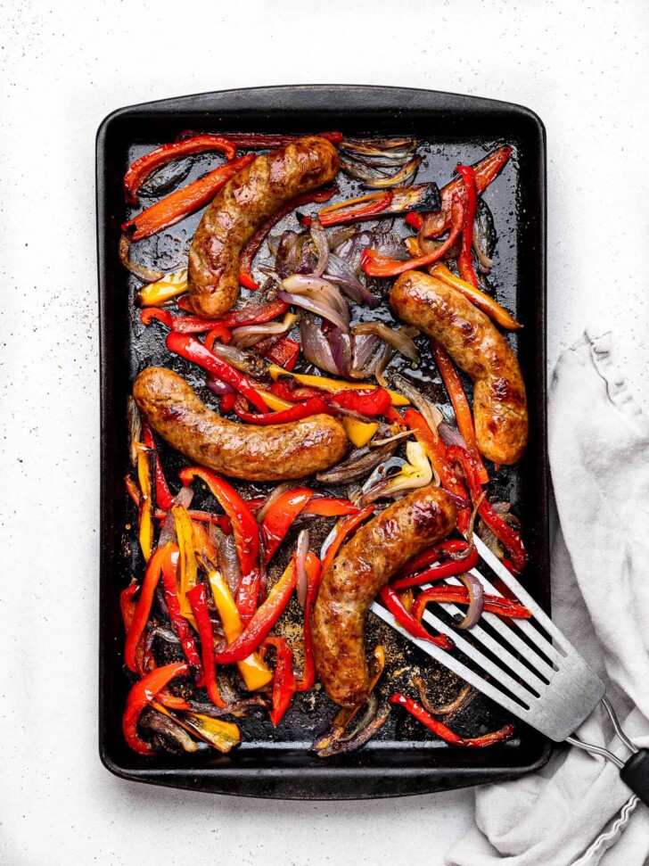 baked sausage, peppers and onions on baking sheet
