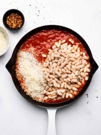 adding tomatoes and beans to skillet