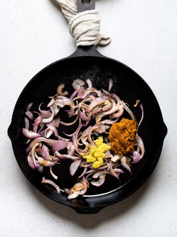 onions, curry paste and ginger cooking in skillet
