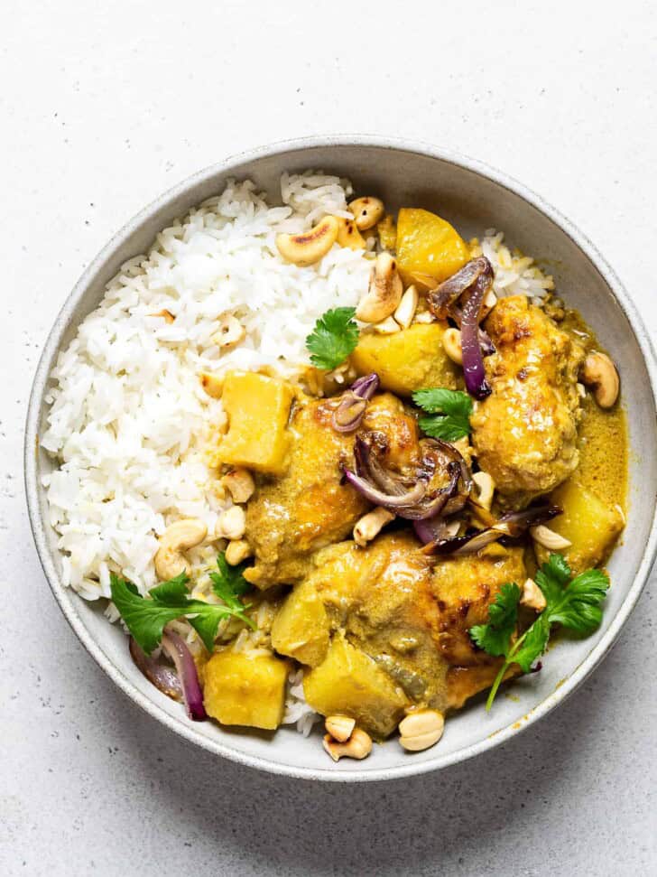 chicken curry served in a bowl with white rice 