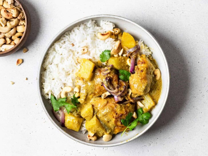 chicken curry served in a bowl with white rice 