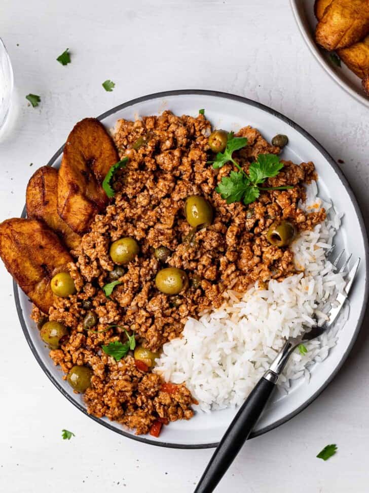 Turkey picadillo served on plate with plantains and rice.