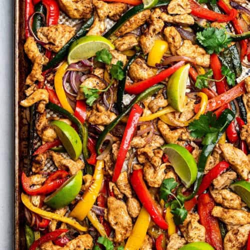 Chicken and vegetables cooked on sheet pan with limes for garnish