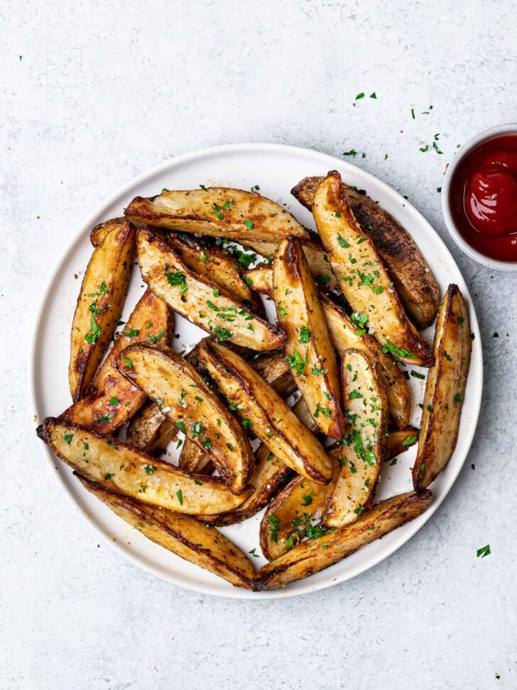 Baked Parmesan Potato Wedges served on plate with ketchup for dipping