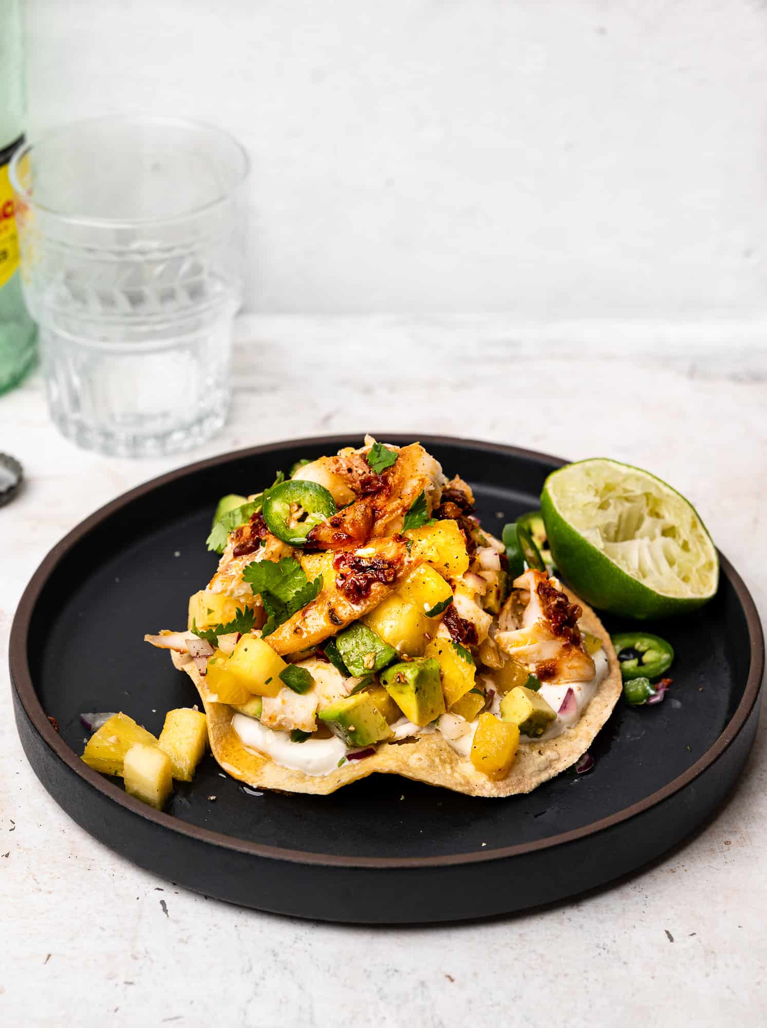 side view of plated fish tostada with pineapple salsa