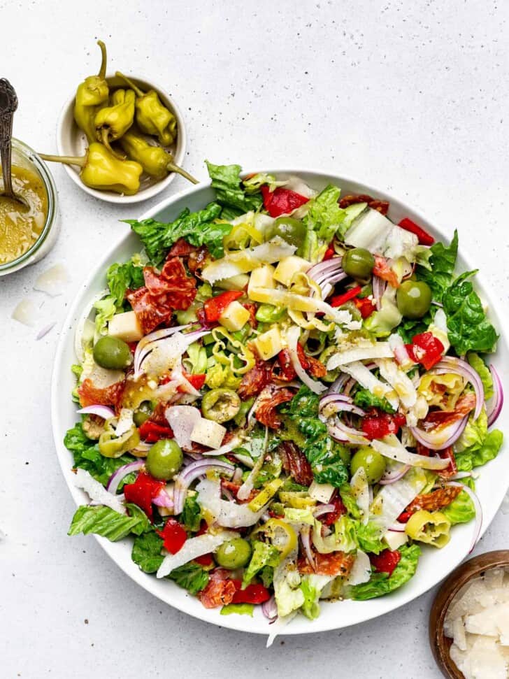Tossed and dressed Italian Salad in bowl with pepperoni in small bowl