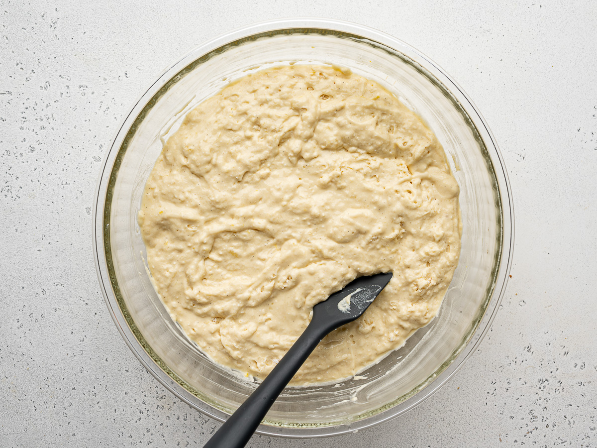 Mixed pancake batter in large glass mixing bowl.