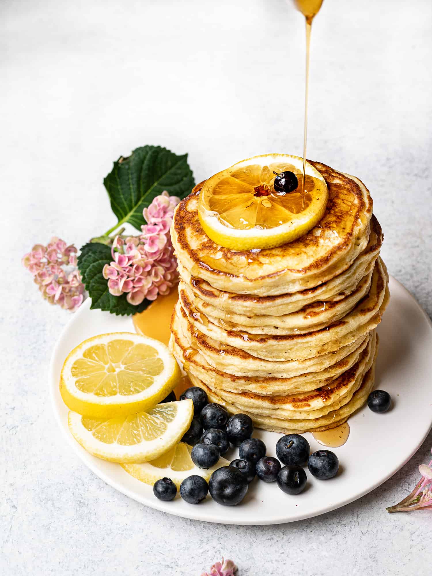 drizzling maple syrup onto pancake stack