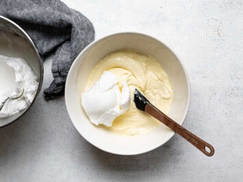 folding egg whites with mascarpone cream mixture in bowl