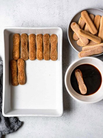 dipping ladyfingers in coffee and arranging them in dish