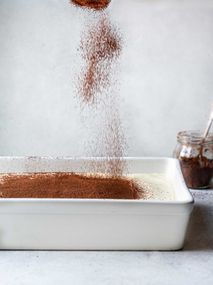Sprinkling easy tiramisú with cocoa powder