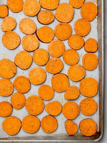 sliced sweet potatoes layered on sheet pan