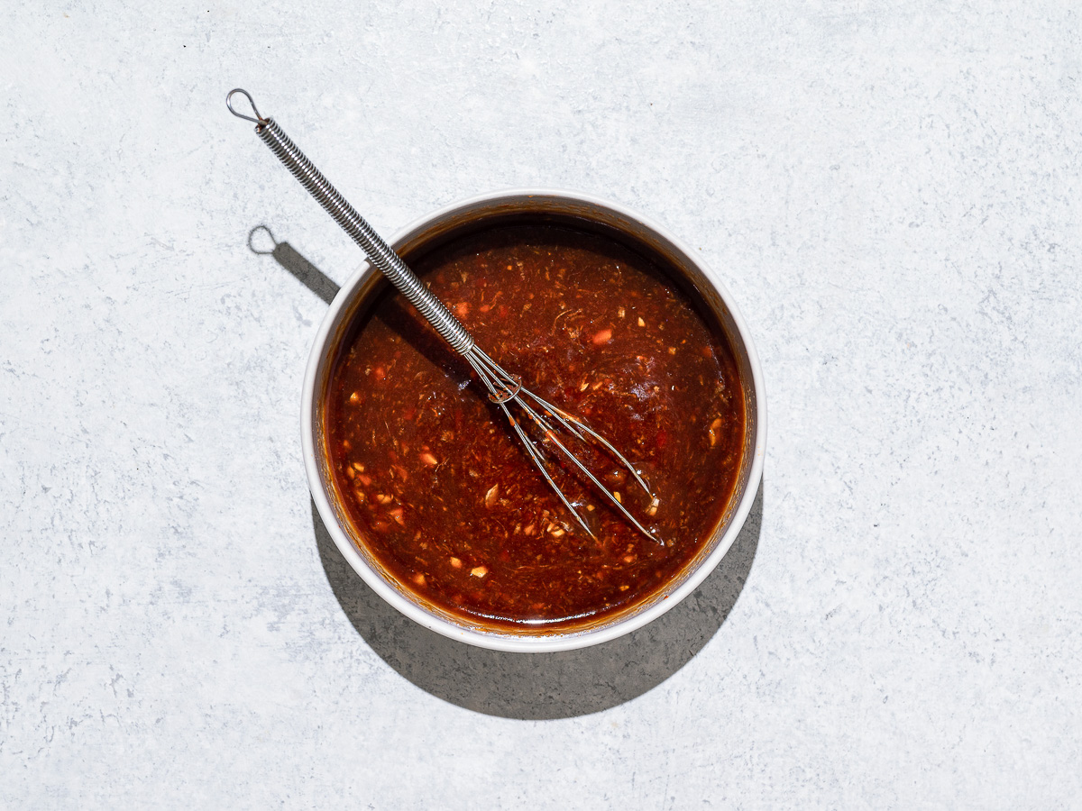 Prepared marinade for chicken drumsticks in bowl. 