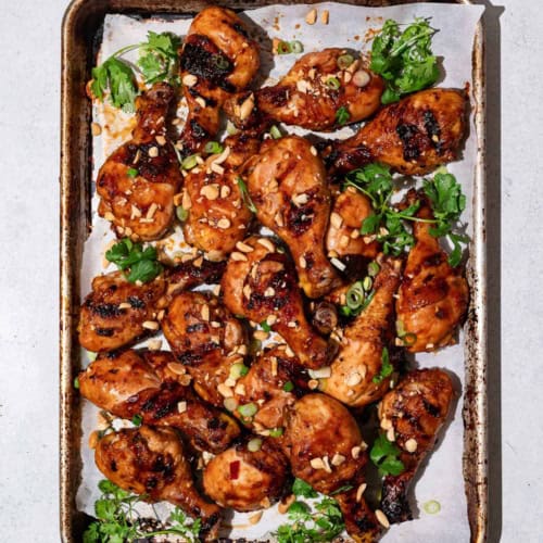 Sweet and sticky grilled drumsticks on sheet pan with crushed peanuts