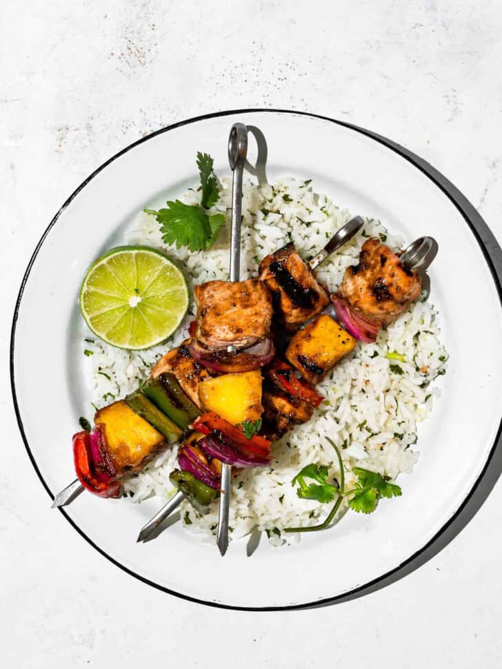 pineapple salmon kabobs served with rice on a plate