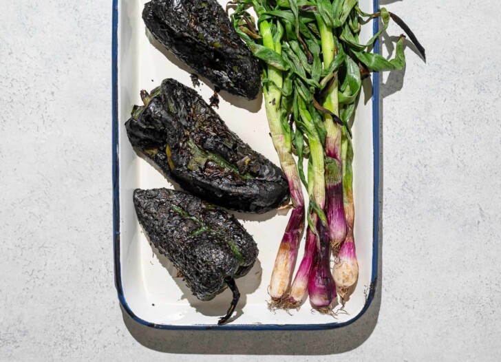 Charred poblano peppers and spring onions on platter