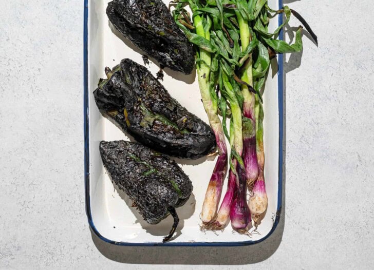 Charred poblano peppers and spring onions on platter