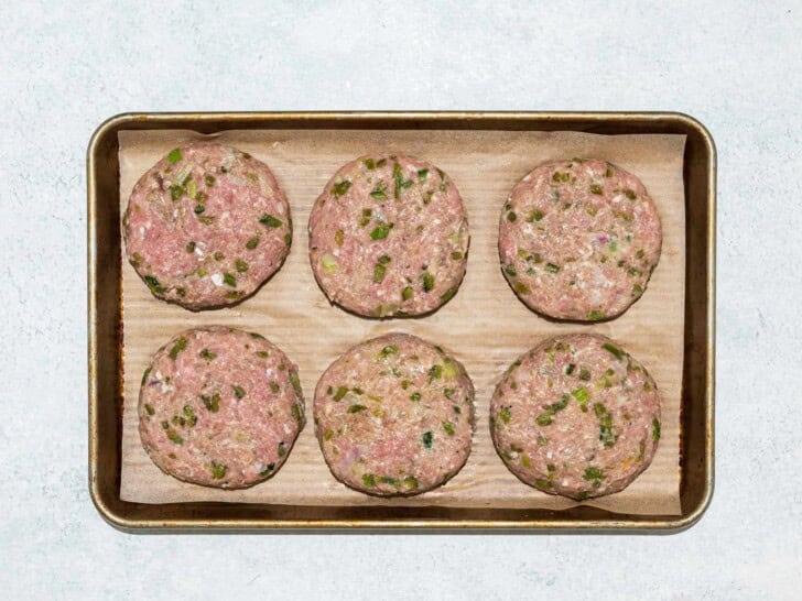 shaped burger patties on baking sheet