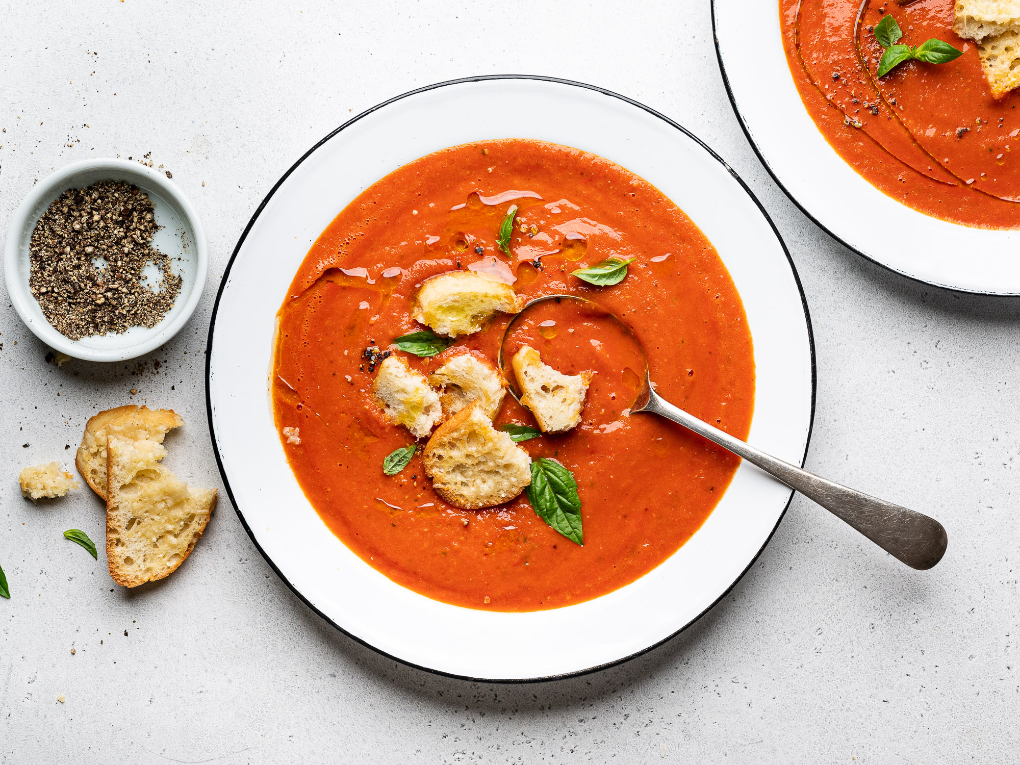 roasted tomato soup served in bowls and topped with parmesan toasts