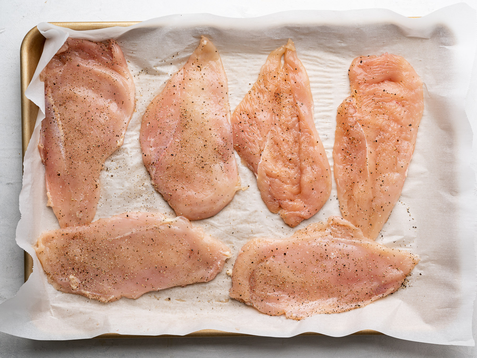 seasoned cutlets on baking sheet