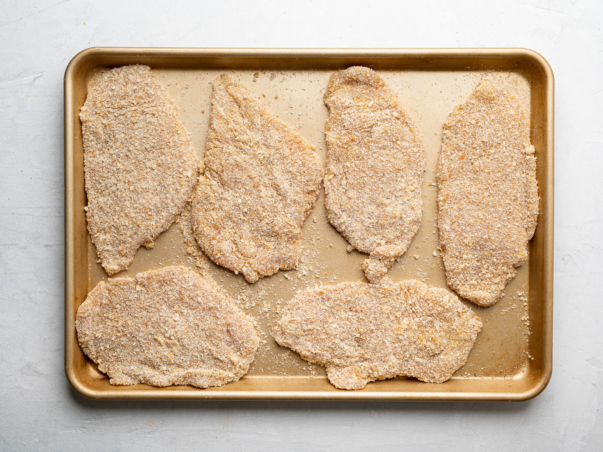 breaded chicken cutlets on baking sheet