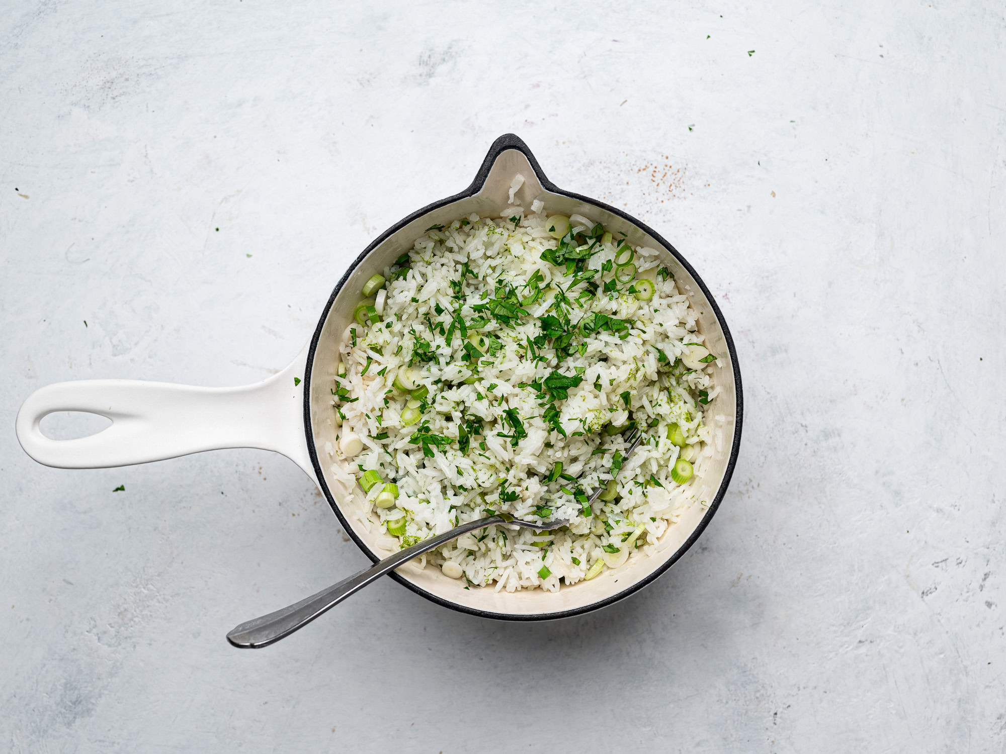 adding cilantro, scallions, lime zest to rice in pot