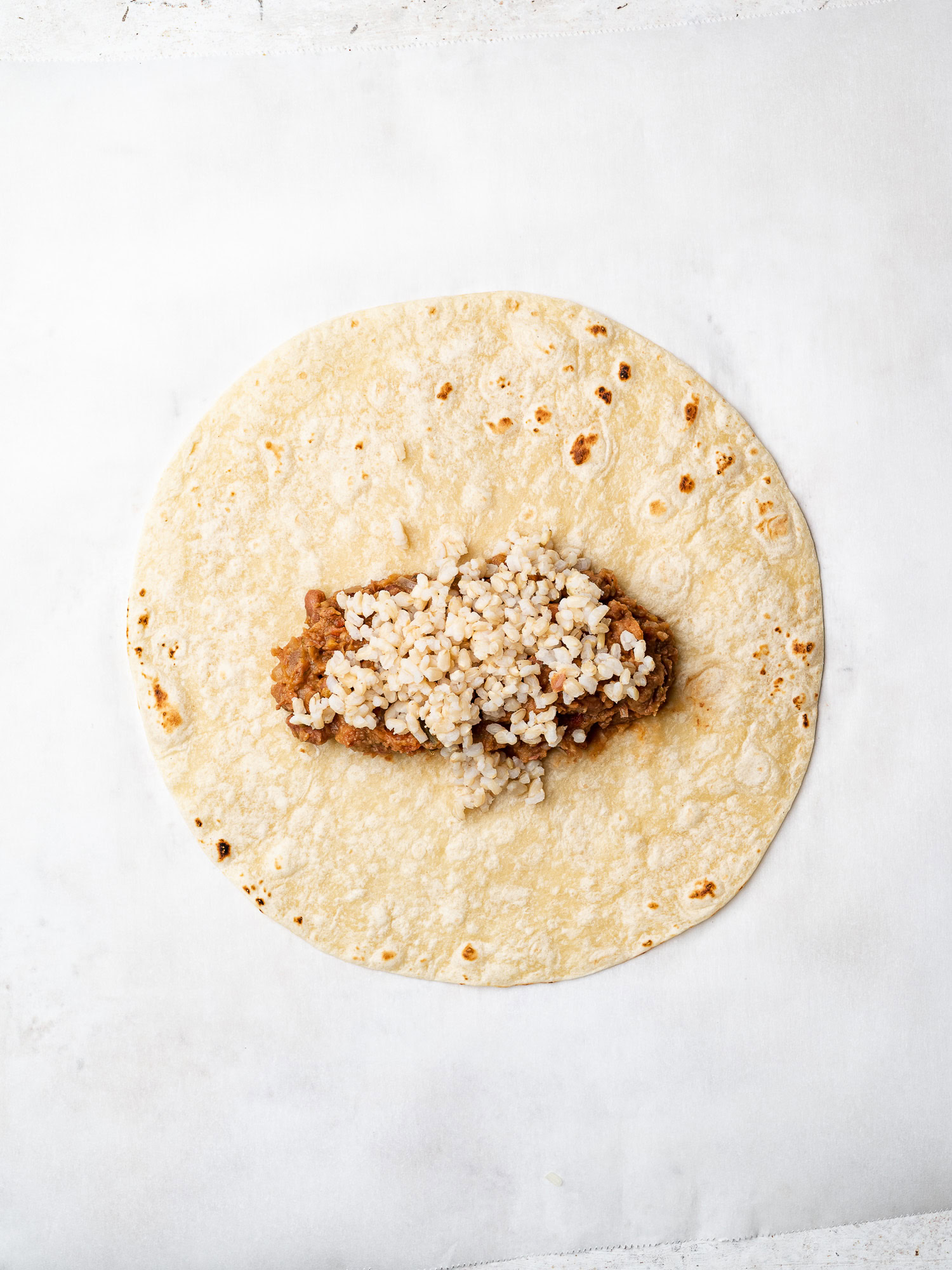 topping rice on refried beans