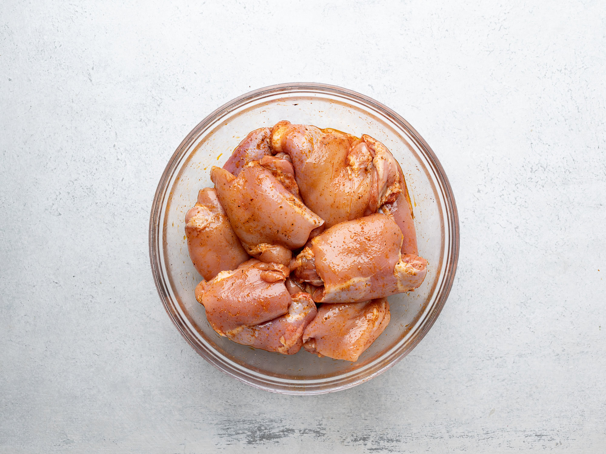 chicken thighs with spices in bowl