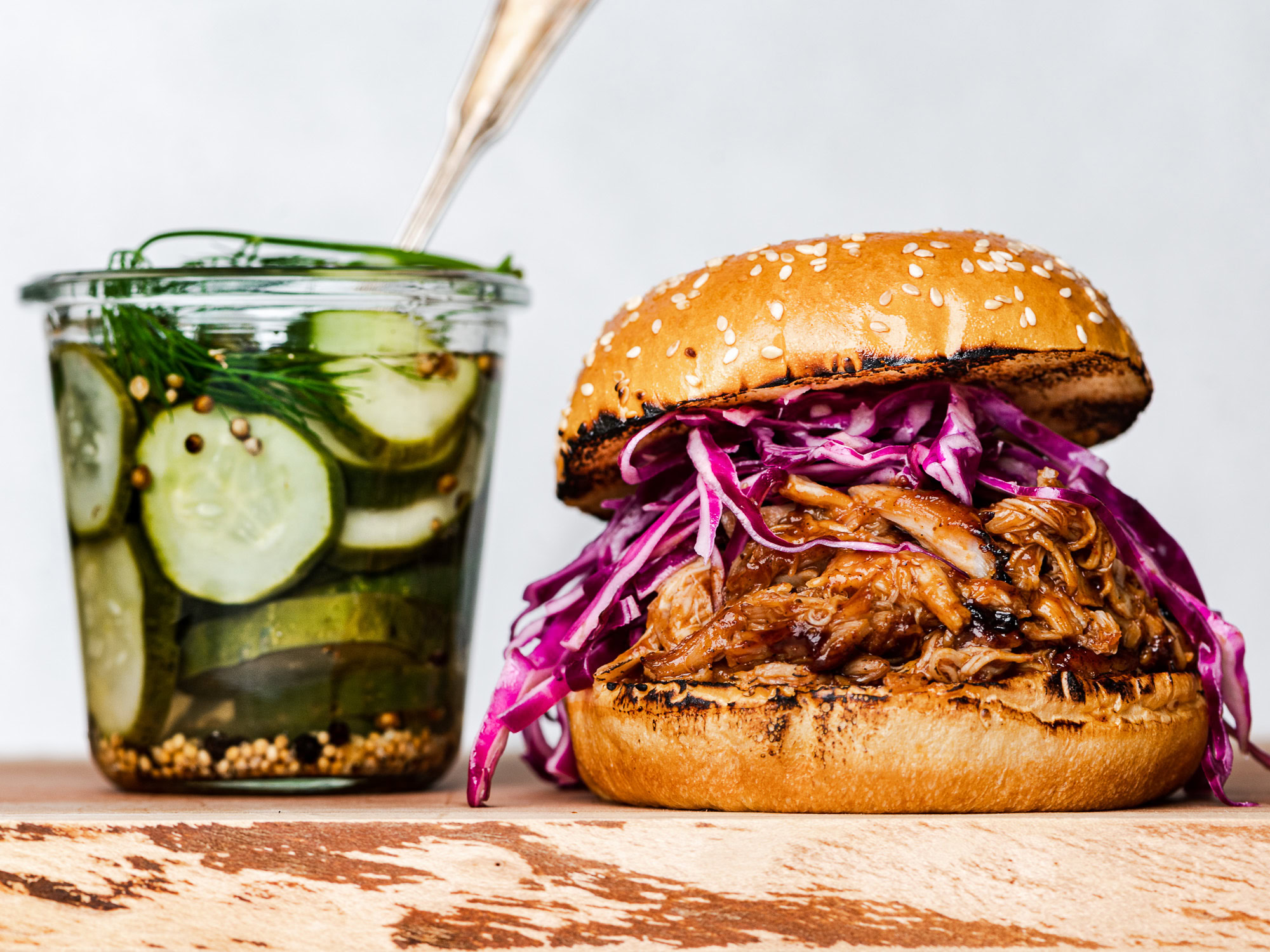 Pulled BBq chicken in a bun with coleslaw and pickle jar