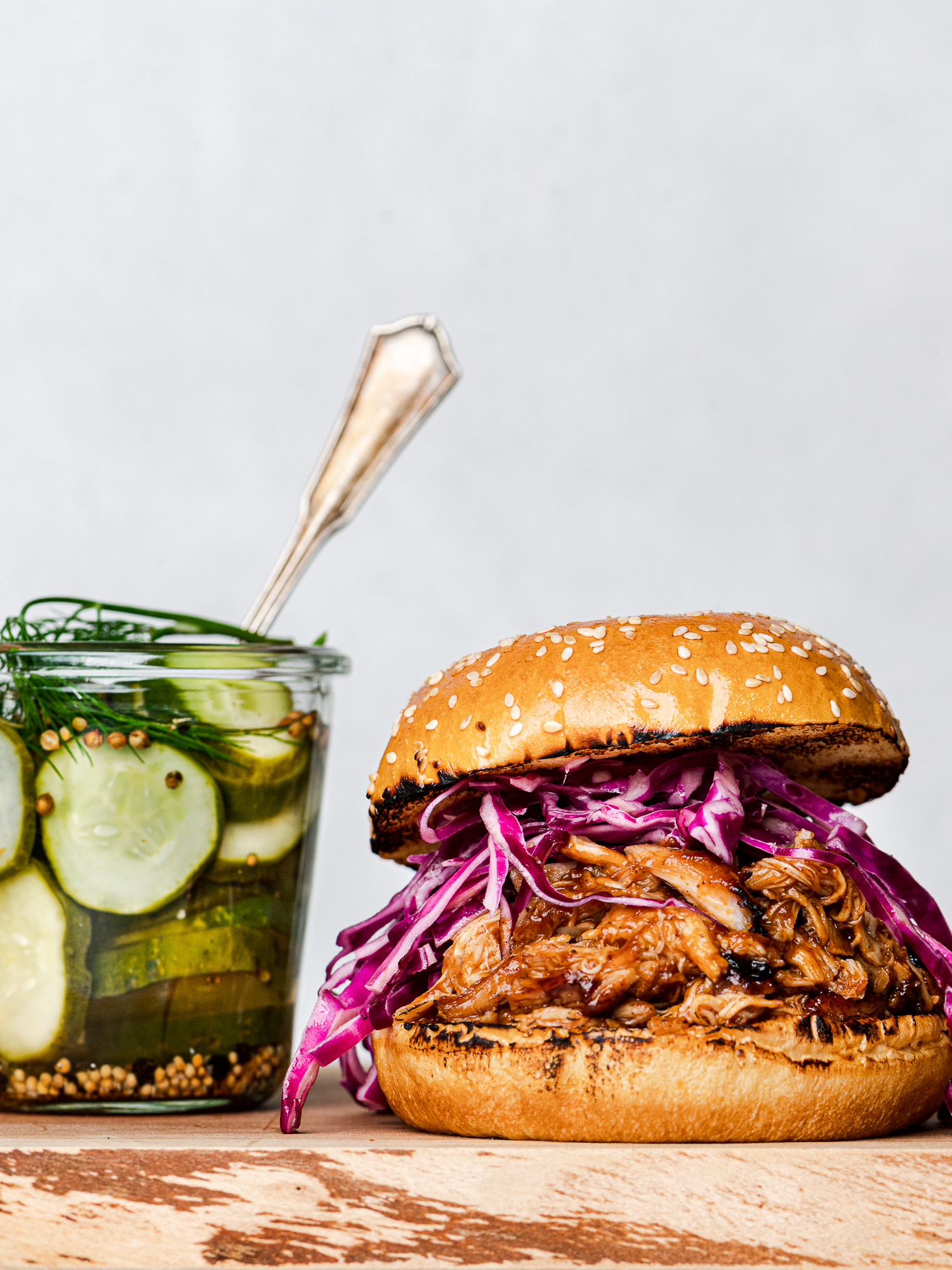 Pulled BBq chicken in a bun with coleslaw and pickle jar