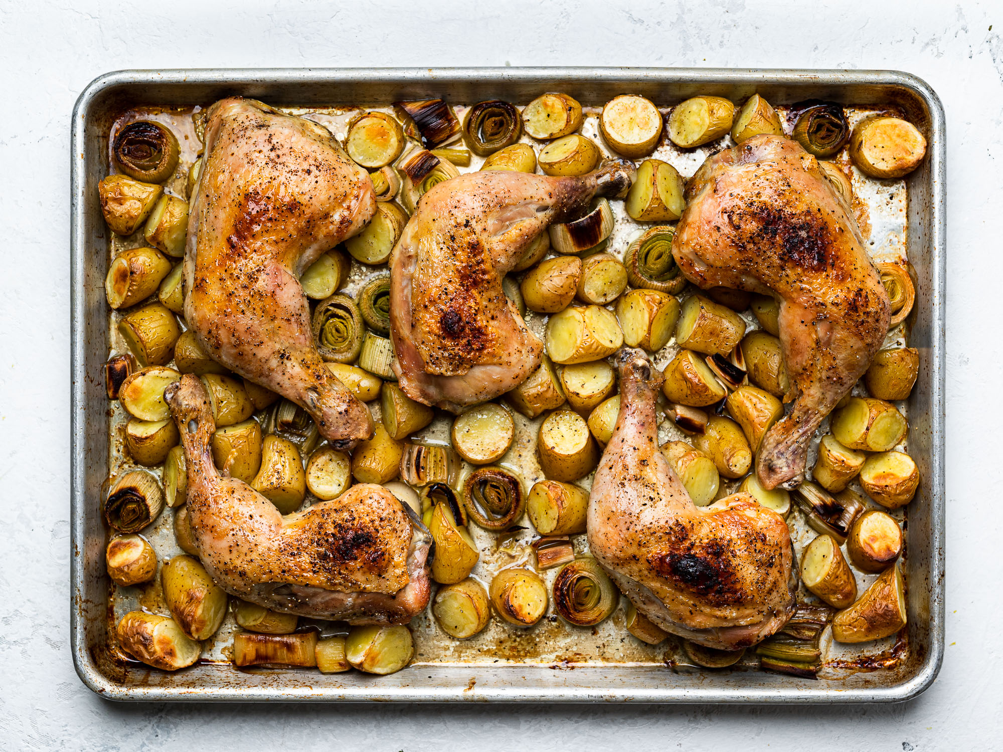 roasted chicken with potatoes and leeks on sheet pan
