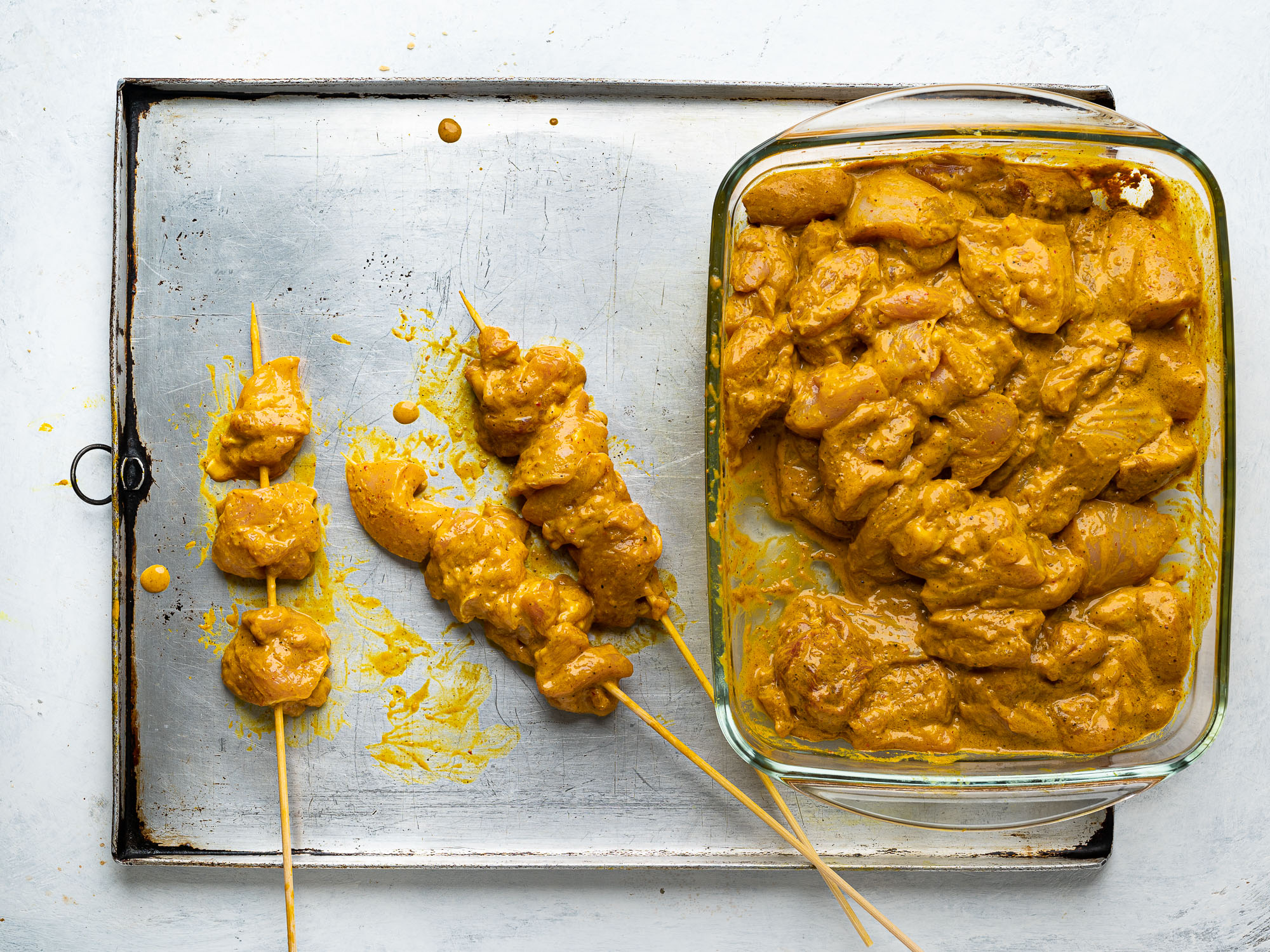 threading chicken pieces through skewers