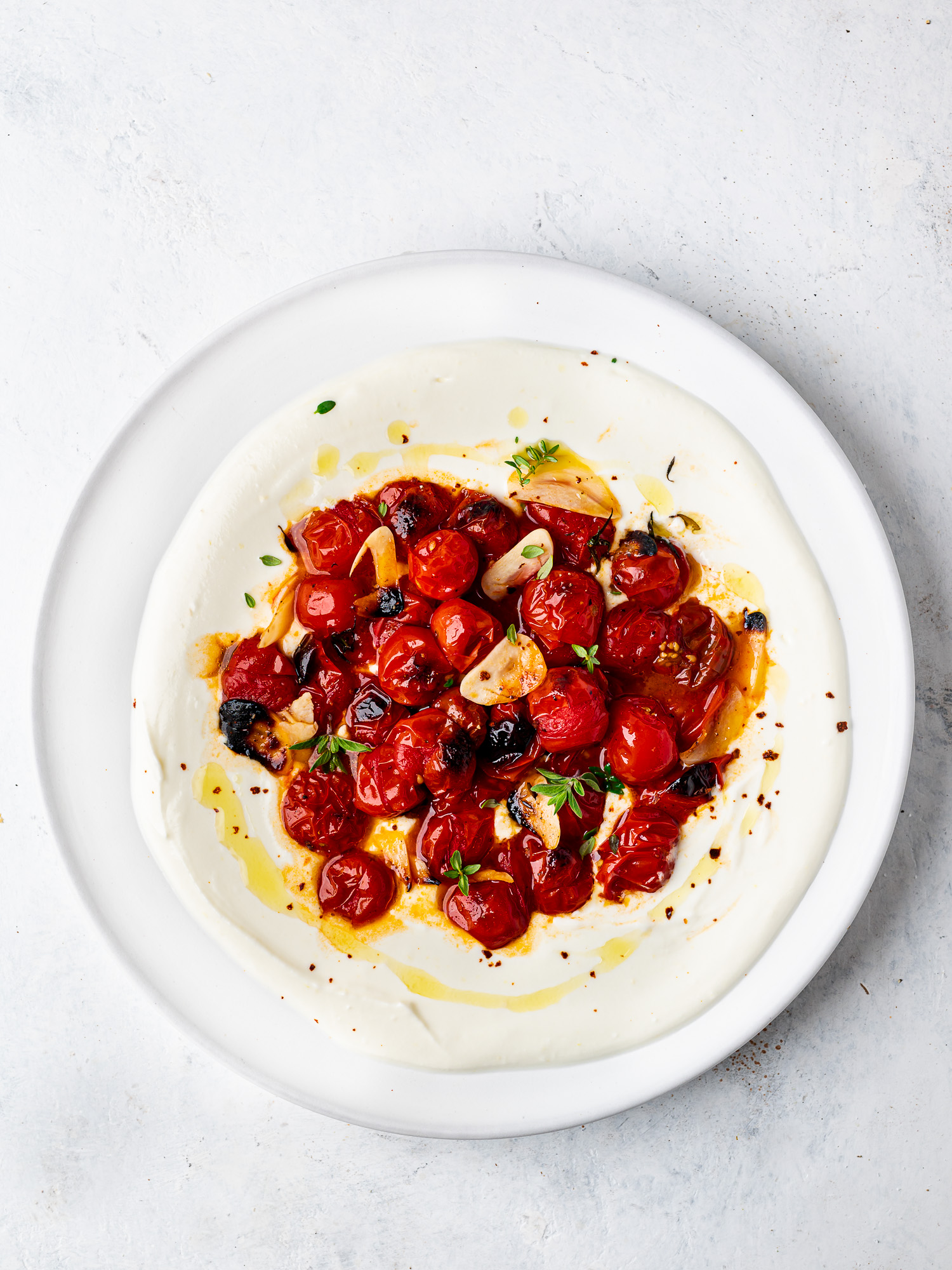 whipped feta topped with roasted cherry tomatoes on platter