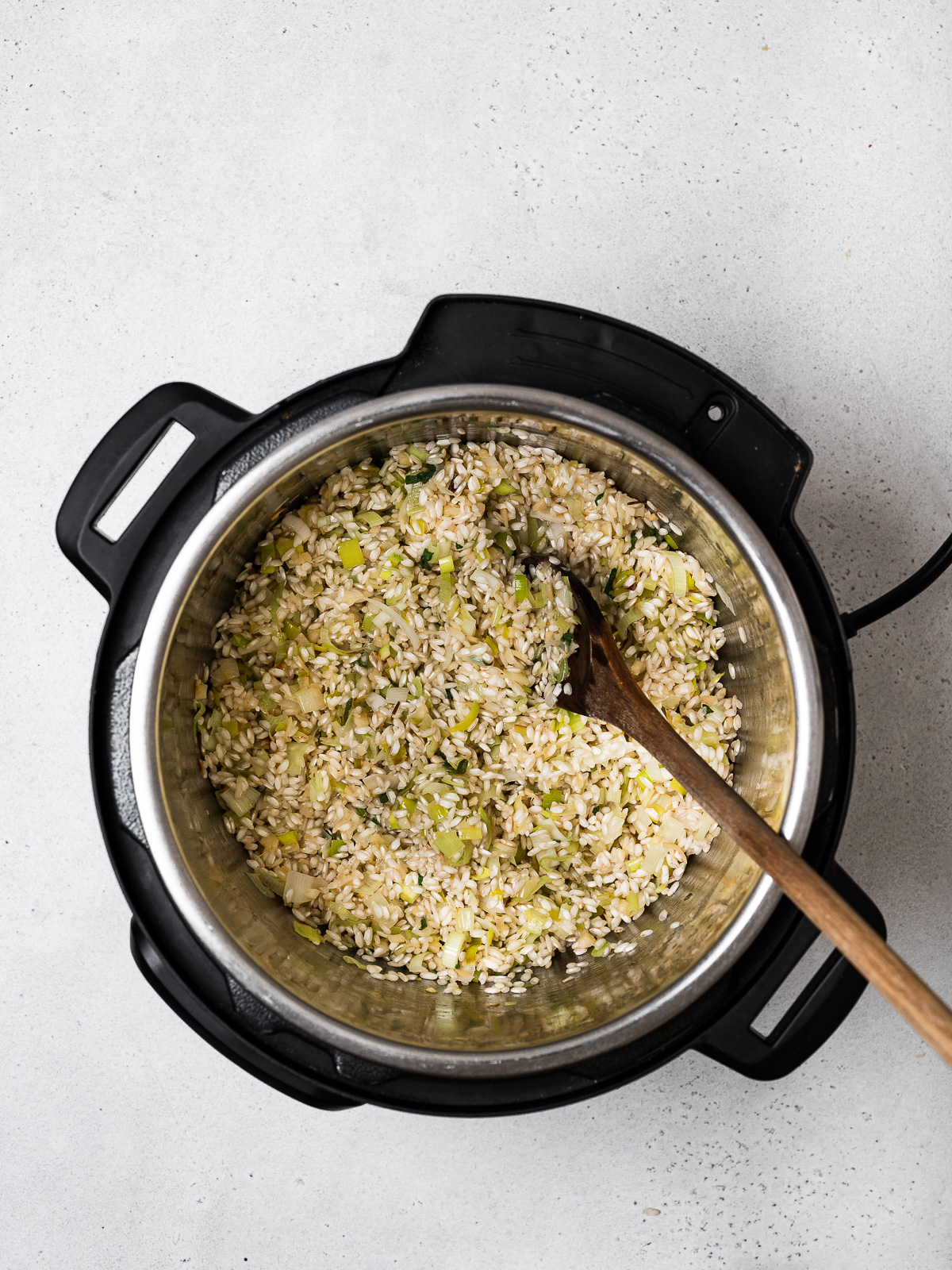 sautéing rice with leeks in pot