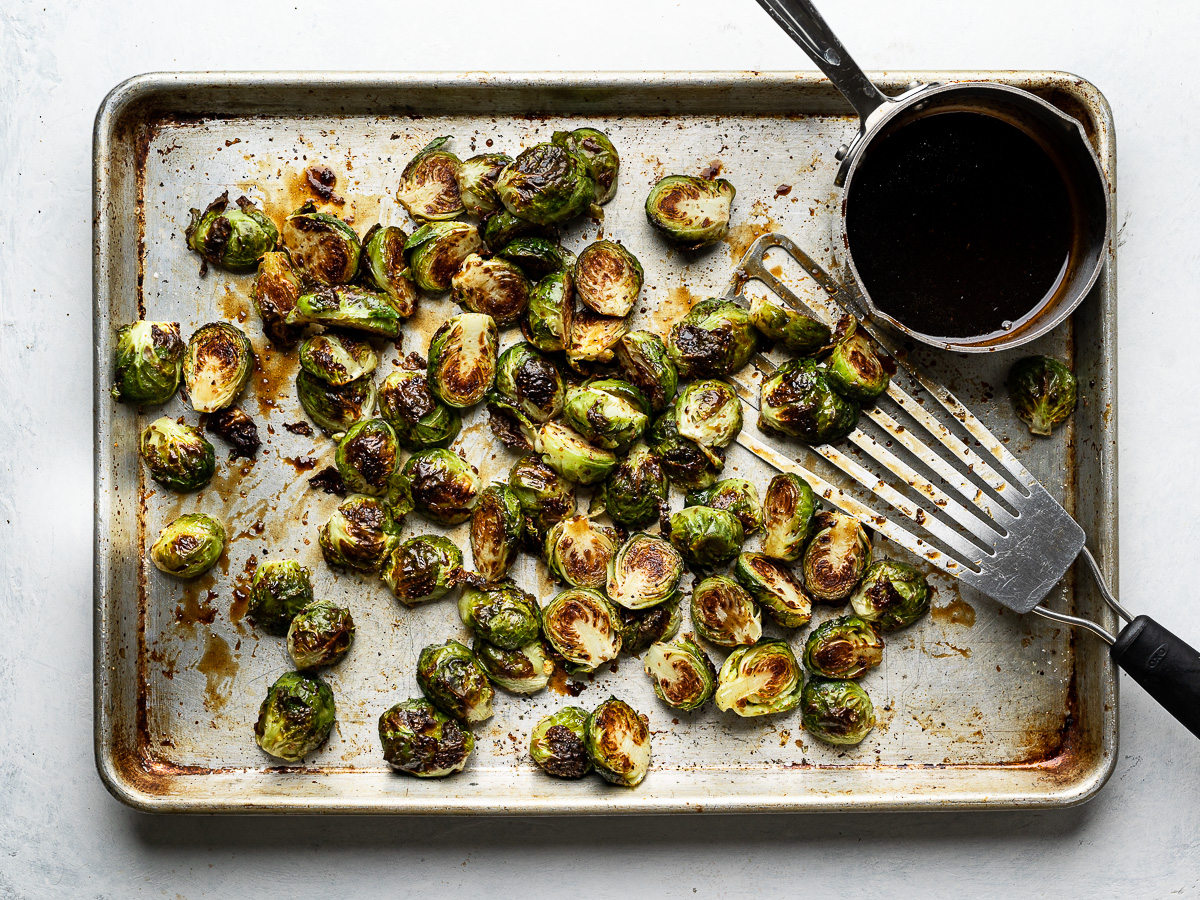 tossing brussels sprouts with balsamic glaze