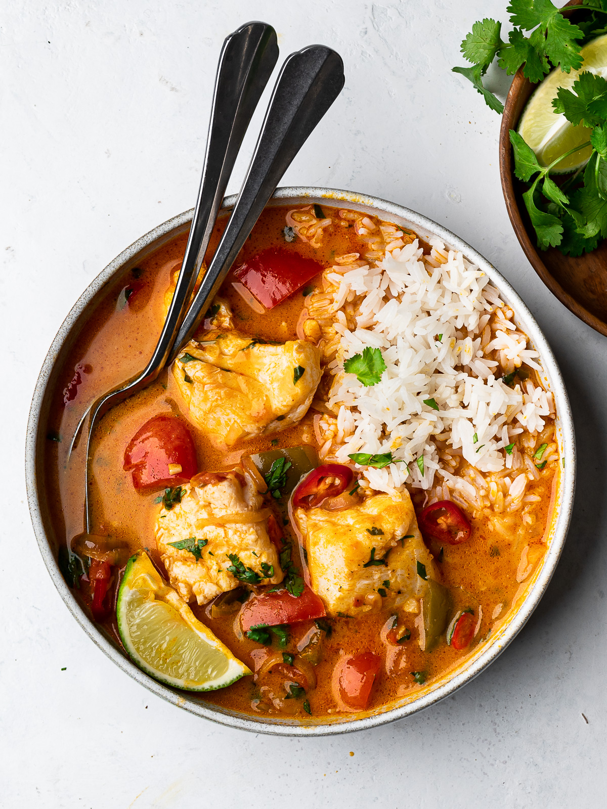Brazilian fish stew (moqueca) served in bowl and topped with rice