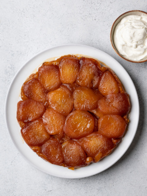 Apple tarte Tatin served on plate with whipped cream on the side