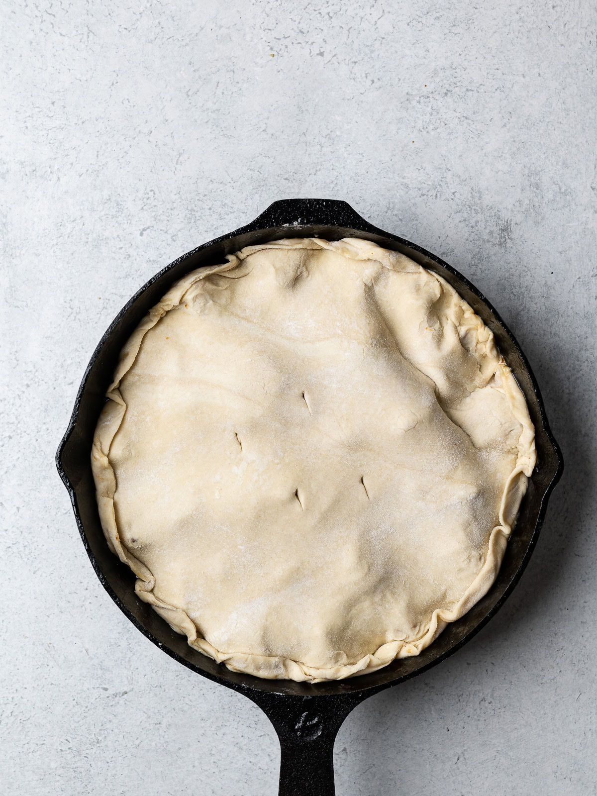 showing puff pasty tucked in around the edges in the skillet 