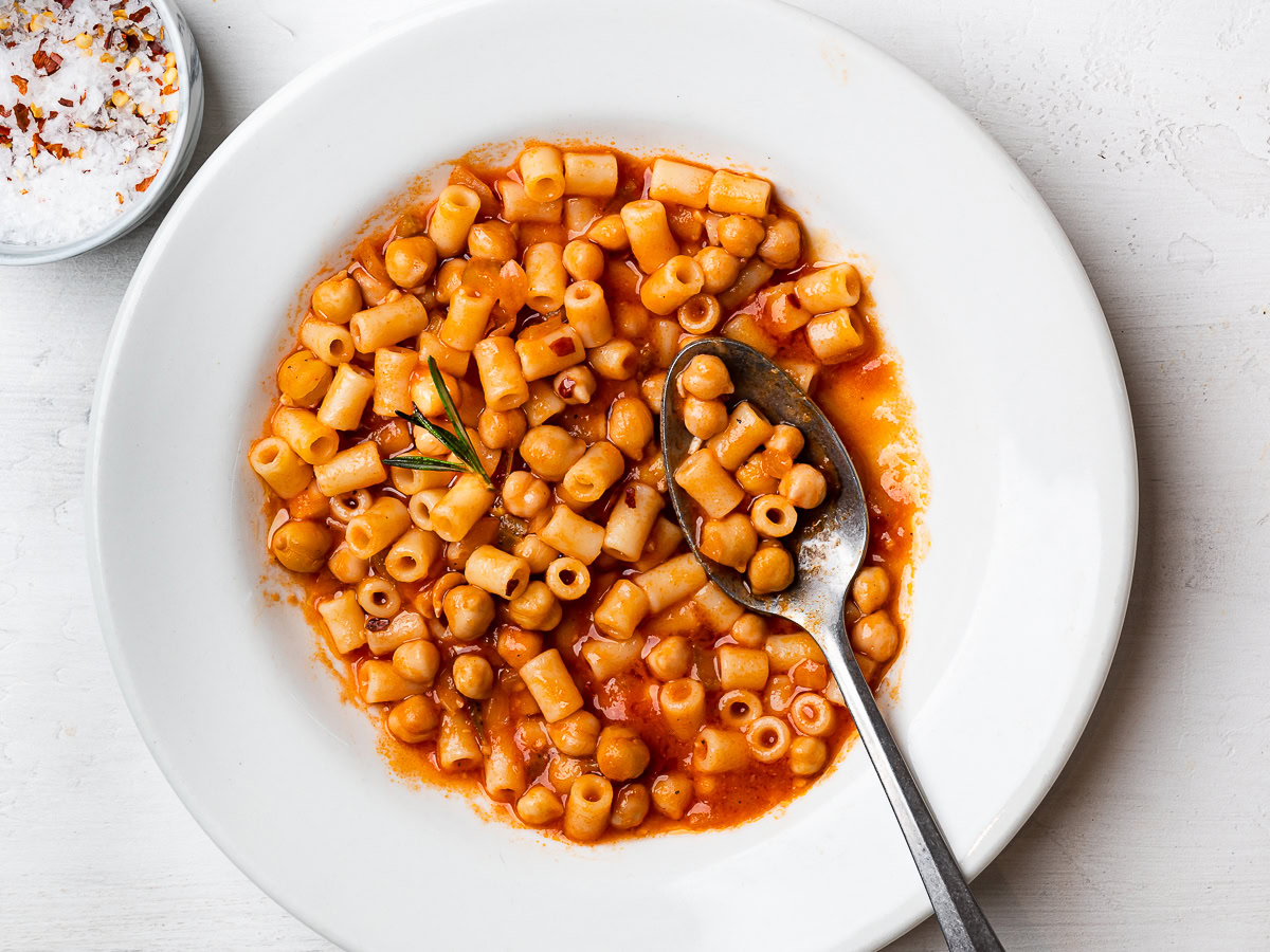 close up of Pasta e ceci - chickpeas and pasta stew served in bowl with spoon