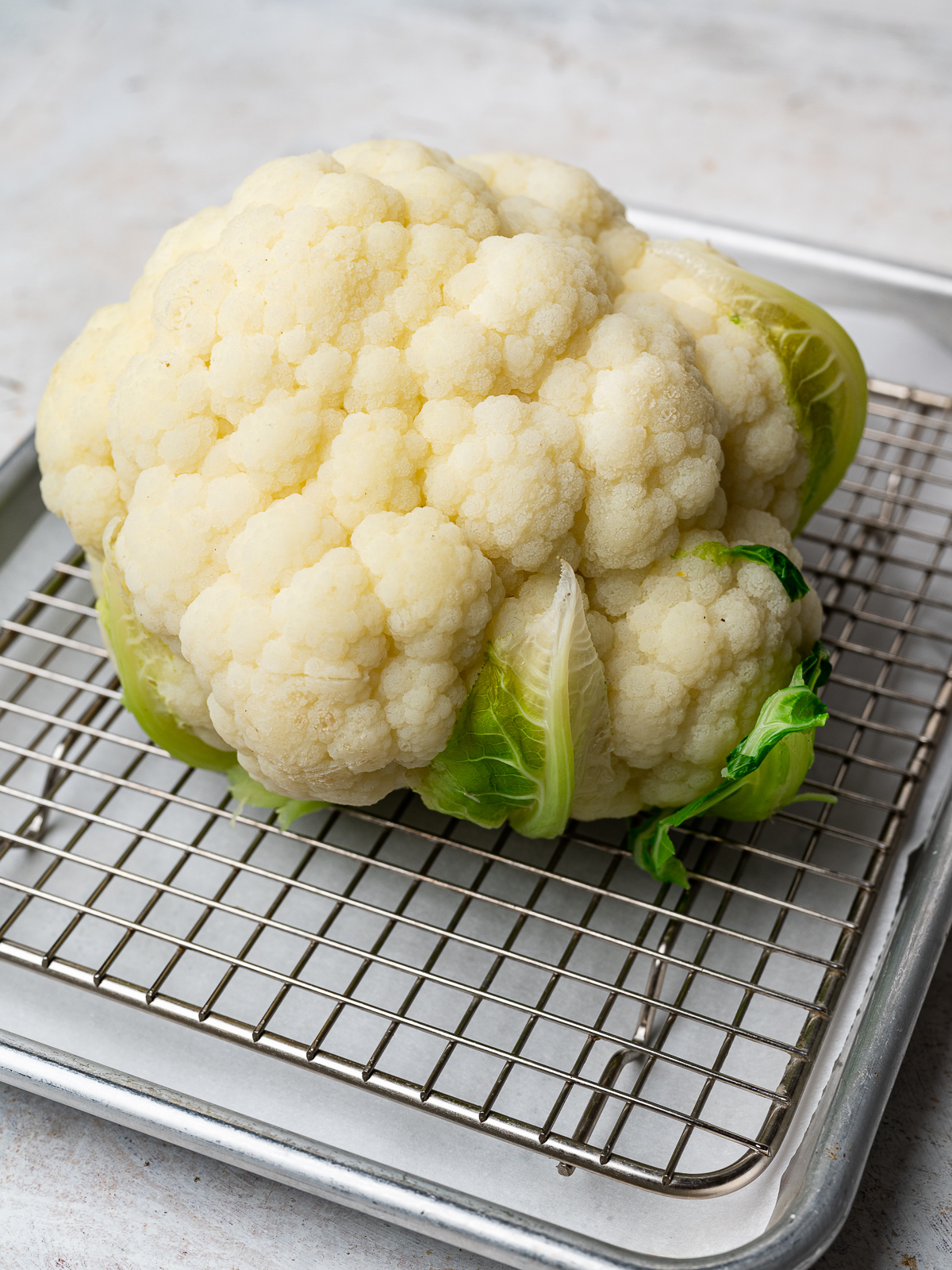 steamed cauliflower cooling off on a rack before getting roasted