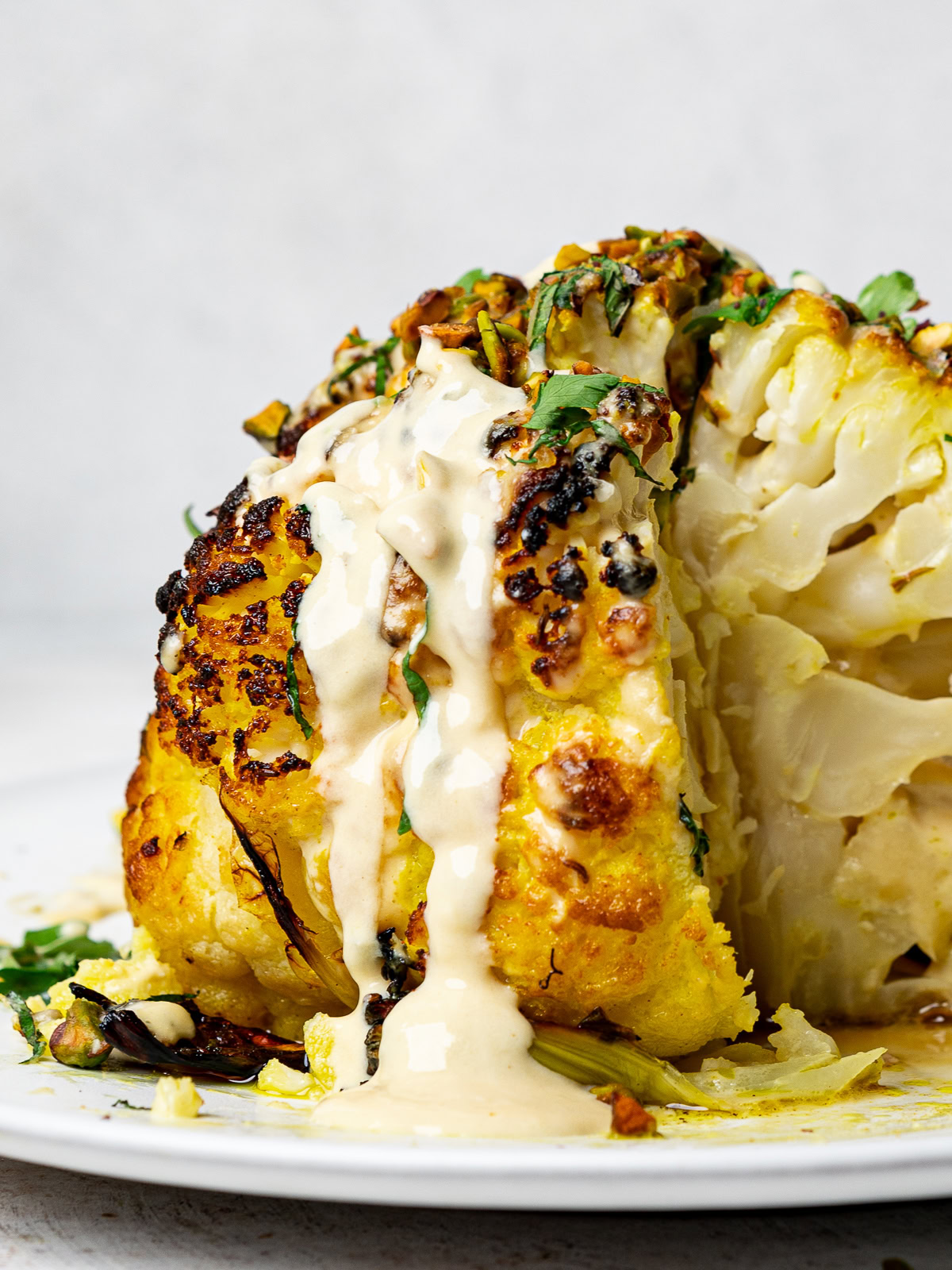 side-view of roasted cauliflower drizzled with tahini sauce