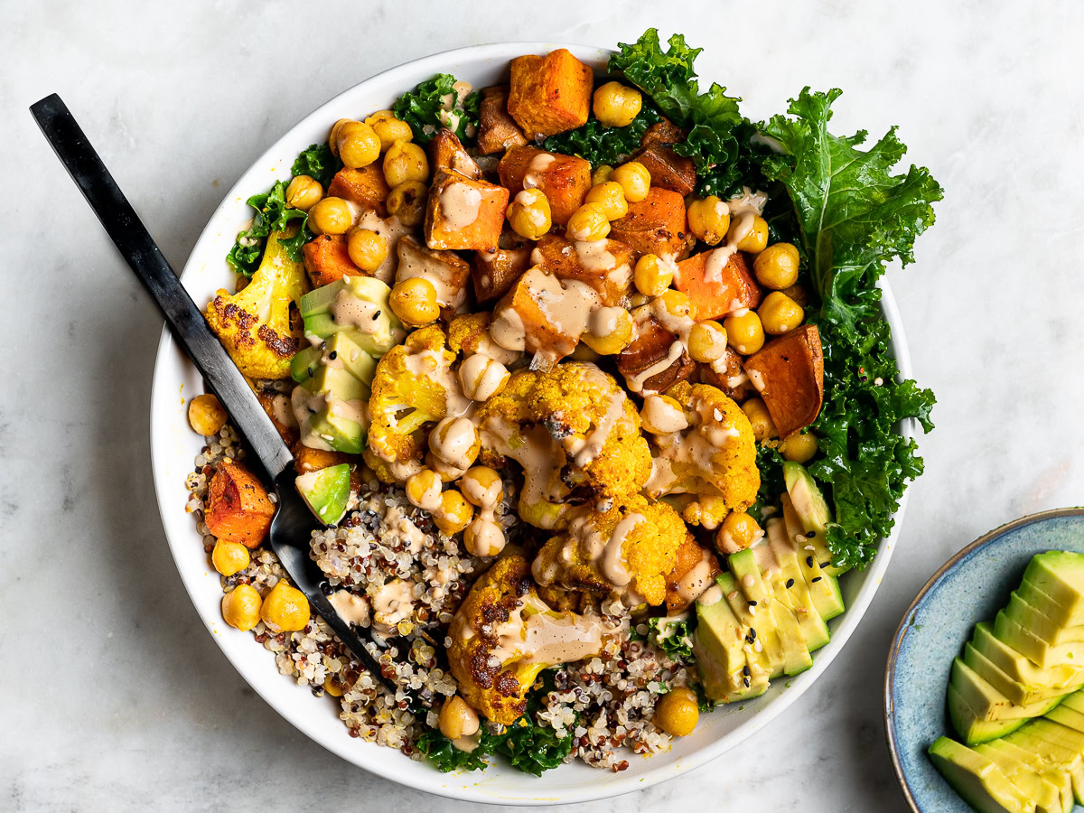 Buddha Bowl with Roasted Veggies with avocado slices on the side