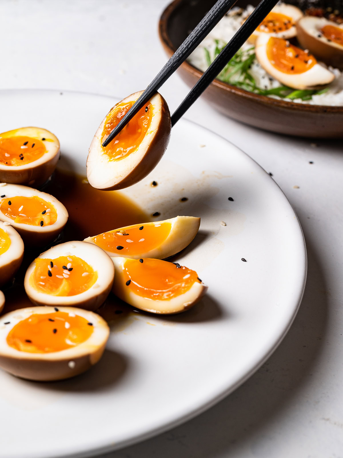 lifting a sliced egg with chop sticks