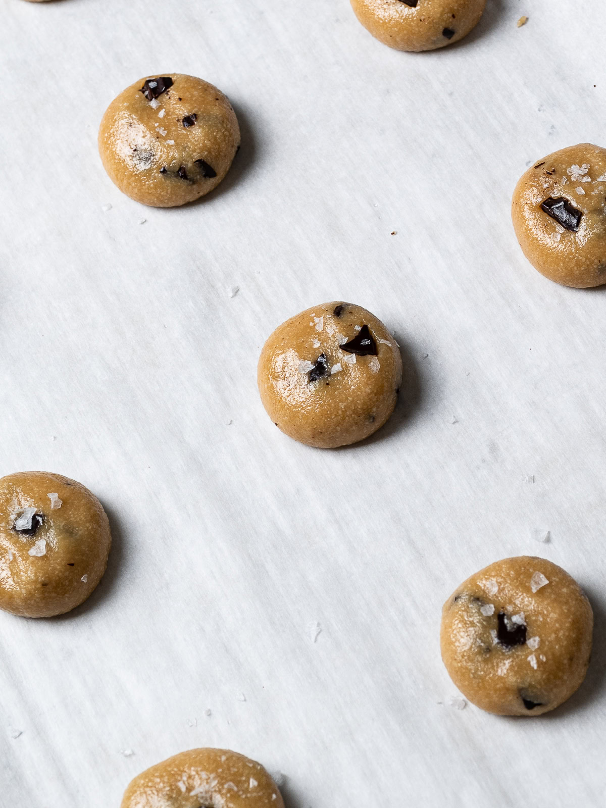 rolled cookie dough balls flattened and sprinkled with flaky salt