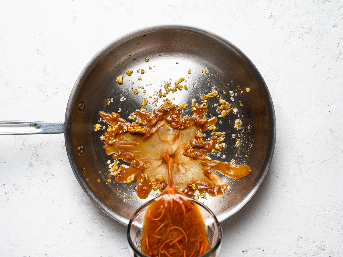 pouring tangerine sauce into pan