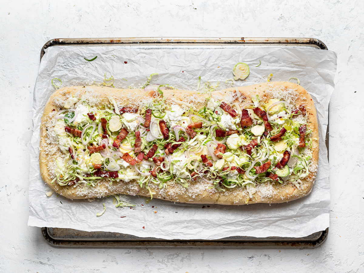 flatbread topped with cheese, brussels sprouts, shallots, and bacon