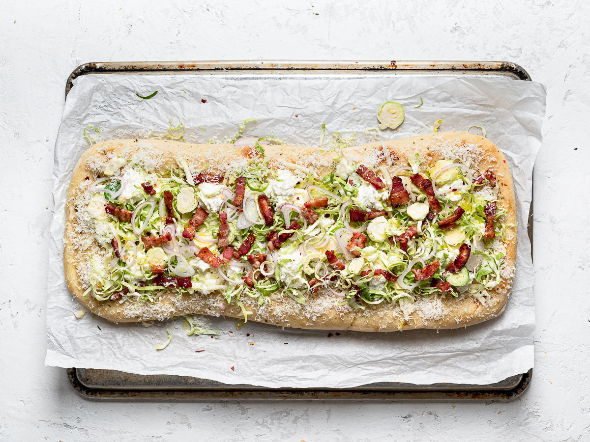 flatbread topped with cheese, brussels sprouts, shallots, and bacon