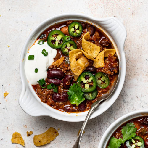 Game day chili served in a bowl with toppings