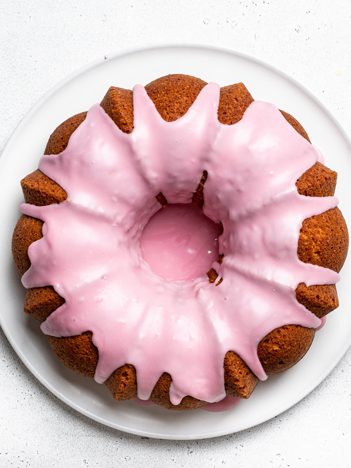 top view of olive oil and yogurt cake drizzled with blood orange glaze